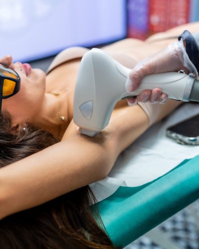 Woman underarm laser hair removal in a beautician clinic